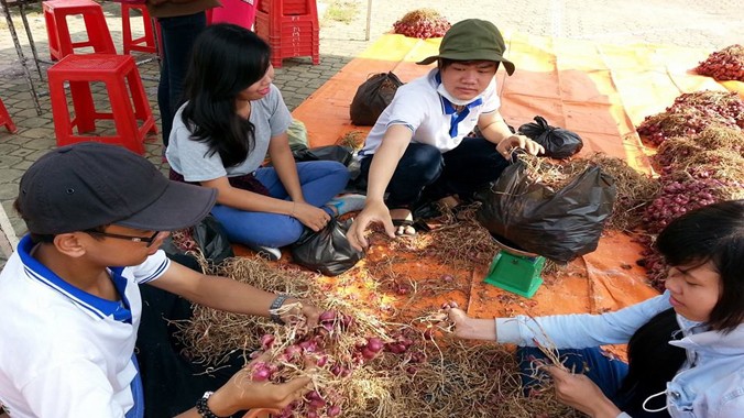 Thanh niên giúp bà con Khmer bán hành tím.