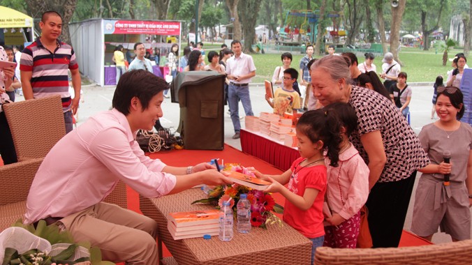 Trần Hùng John giao lưu cùng độc giả tại trong Ngày Sách Việt Nam 2015 tại công viên Thống Nhất, Hà Nội. Ảnh: N.M.Hà.