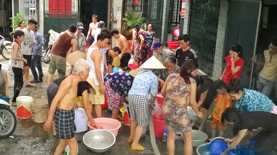 Người dân ở ngõ 243 Giáp Bát - Hà Nội đi lấy nước sạch của Cty Viwaco cung ứng nước vào ngày 23/5/2014. Ảnh: Như Ý.