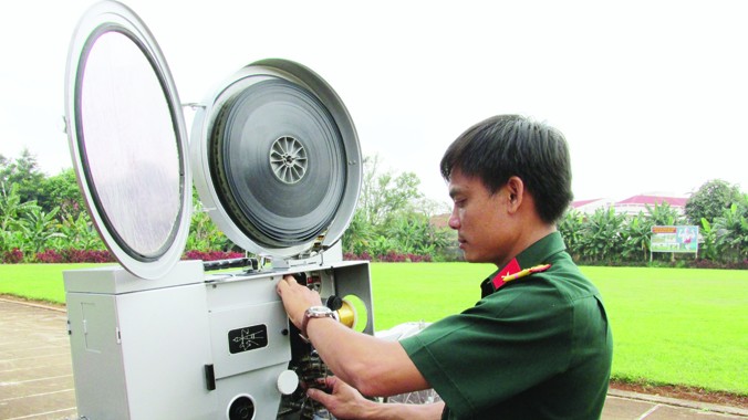 Anh Trương Huy Thái ráp phim vào máy, chuẩn bị trước cho buổi chiếu phim.