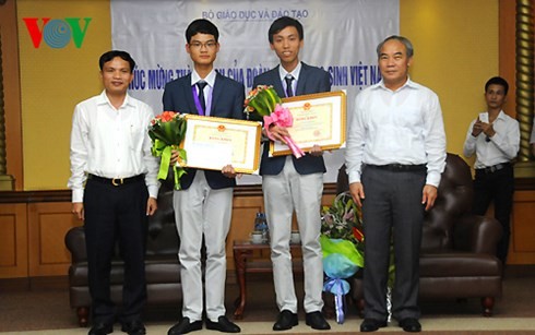 Thứ trưởng Nguyễn Vinh Hiển trao bằng khen cho 2 học sinh đạt huy chương Vàng. Ảnh VOV 