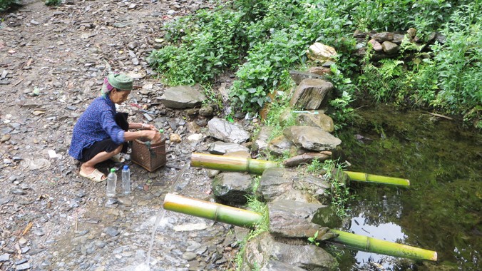 Công trình nước sạch bị bỏ hoang, trong khi người dân ở bản Nậm Cày, xã Chăn Nưa (Sìn Hồ, Lai Châu) phải gùi nước cạnh công trình nước sạch. Ảnh: Quỳnh Nga.