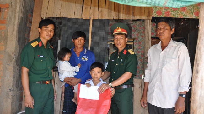 Chỉ huy Đại đội trao tiền và quà tiếp bước đến trường cho học sinh nghèo biên giới.