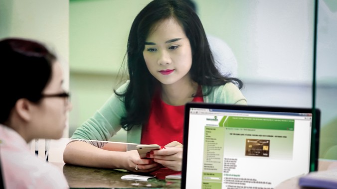 Nhân viên Vietcombank tư vấn cho khách quan tâm đăng ký sử dụng thẻ đồng thương hiệu.