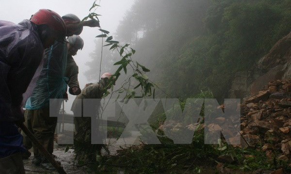 Công nhân Hạt Giao thông 4 thu dọn đất đá ở những điểm sạt lở trên tuyến đường lên Khu du lịch Mẫu Sơn, Lạng Sơn. (Ảnh: Doãn Hoàng Nam/TTXVN)