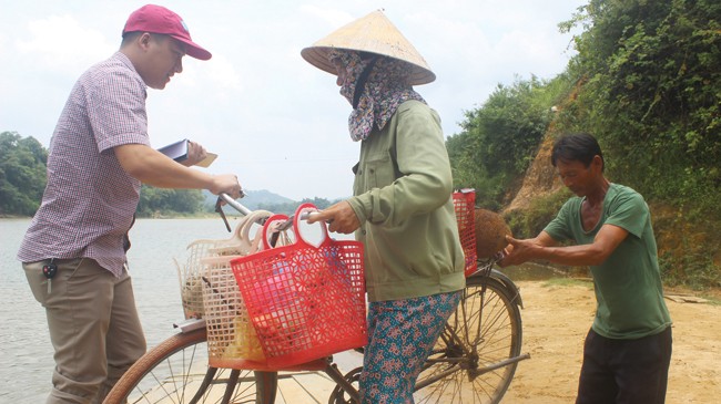 Chị Phạm Thị Liên vất vả đỡ chiếc xe đạp lên đò để qua thôn Liên Hòa.