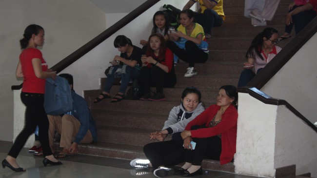 Thí sinh và phụ huynh vất vả ngồi ở cầu thang để chờ rút hồ sơ tại ĐH Sư phạm TPHCM. Ảnh: Nguyễn Dũng.