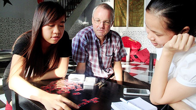 Chủ quán Nguyễn Thị Thu Thanh (áo đen, bên trái) giới thiệu về trò chơi do cô sáng tạo. Ảnh: H. Văn.