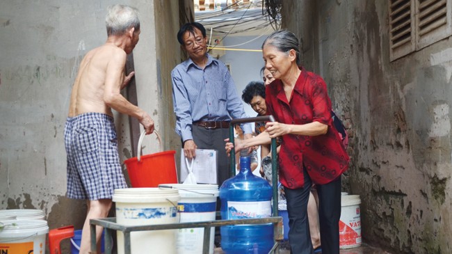 Người dân lấy nước từ xe chở nước sạch tại ngõ 61 Nguyễn Văn Trỗi (Thanh Xuân - Hà Nội). Ảnh: Thanh Hà.