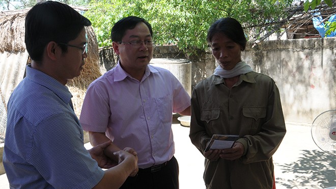 Đại diện lãnh đạo báo Tiền Phong (giữa) và huyện Thanh Chương trao sổ tiết kiệm cho bà Nguyễn Thị Kim.