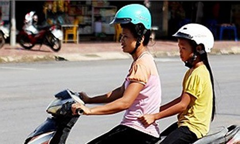 Phụ nữ dân tộc Thái gặp khó khăn khi đội mũ bảo hiểm do có búi tóc