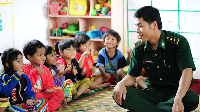 Trung úy Nguyễn Bá Truyền đang dạy Tranh (thứ 4 từ trái sang) và các cháu nhỏ ở trường mầm non A Đớt ca hát.