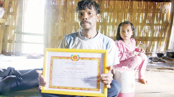 Ông Bnươch Bốn (62 tuổi) với tấm giấy khen được Đảng bộ xã A Rooi trao tặng vì hành động tình nguyện hiến đất làm đường. Ảnh: Thanh Trần.
