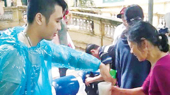 Nguyễn Đức Huy cùng Nhóm Chia sẻ vì cộng đồng đội mưa phát cháo ở Bệnh viện K (Quán Sứ - Hà Nội).