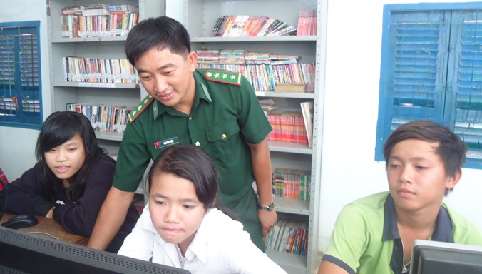 Cán bộ Trạm biên phòng Thiềng Liềng (thuộc Đồn biên phòng Thạnh An) đang hướng dẫn các em học sinh làm quen với máy vi tính.