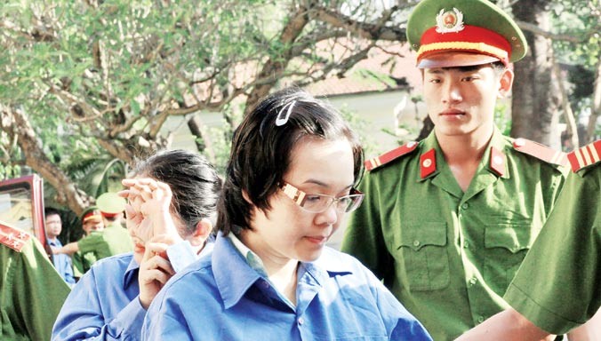 Huỳnh Thị Huyền Như được cảnh sát tư pháp hộ tống đưa vào phòng xét xử tại TPHCM ngày 15/12/2014. Ảnh: Tân Châu.