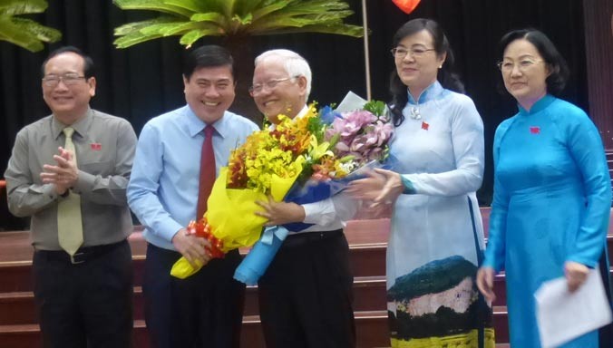 Tân Chủ tịch Nguyễn Thành Phong (thứ 2 từ trái qua) tặng hoa cho cựu Chủ tịch UBND TPHCM Lê Hoàng Quân.