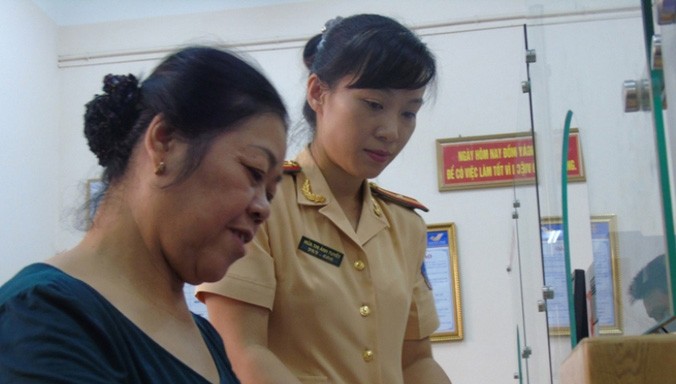Trung tá Hứa Thị Ánh Tuyết hướng dẫn người dân làm thủ tục cấp giấy tờ đăng ký xe.