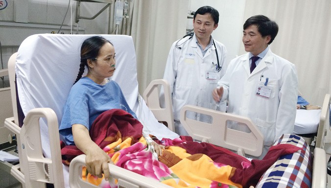 PGS.TS Phạm Đức Huấn (phải) và TS.Hoàng Bùi Hải thăm bệnh nhân H. Ảnh: T.Hà.