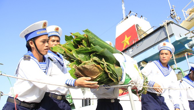 Các chiến sĩ vận chuyển lá dong gói bánh chưng xuống tàu đi Trường Sa. Ảnh: Trường Phong.