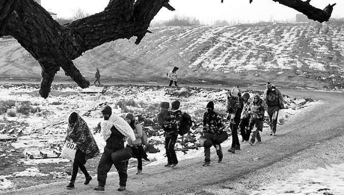 Những người tị nạn phải quấn chăn vào người để giữ ấm khi đi qua biên giới Macedonia.