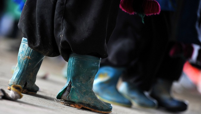 Không ít em nhỏ chống chọi với thời tiết mưa tuyết chỉ với đôi ủng rách toạc gót. Ảnh: Xuân Tùng.