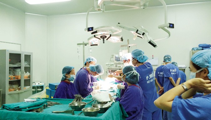 GS.TS Trịnh Hồng Sơn và kíp mổ đang phẫu thuật cho bệnh nhân ung thư. Ảnh: T.Hà.