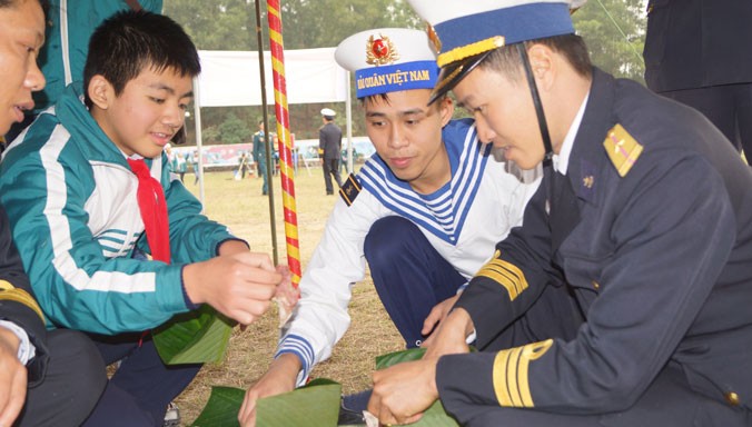 Cán bộ, chiến sĩ Lữ đoàn Hải quân đánh bộ 147 và các em học sinh cùng gói bánh chưng tặng người nghèo đón Tết. Ảnh: Nguyễn Minh.