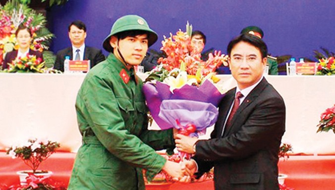 Tân binh Ngô Quang Huy nhận hoa của Chủ tịch UBND Quận Thanh Xuân Nguyễn Xuân Lưu tại lễ giao, nhận quân. Ảnh: Hồng Thái.
