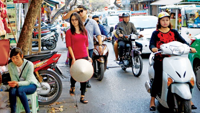 Du khách nước ngoài rất sợ đi bộ dưới lòng đường nhưng cũng không còn cách nào khi vỉa hè đã bị chiếm dụng (ảnh chụp ở phố Đinh Liệt, Hà Nội, ngày 29/2). Ảnh: Ngọc Châu.
