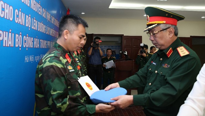 Thượng tướng Nguyễn Chí Vịnh trao quyết định và mũ nồi xanh - biểu tượng của lực lượng gìn giữ hòa bình Liên Hợp Quốc cho 5 sỹ quan.