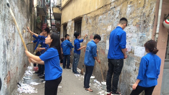 Các bạn đoàn viên, thanh niên Thủ đô quét vôi cho những bức tường cũ loang lổ.