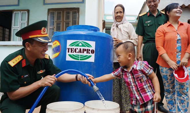 Thượng tá Đinh Quốc Hùng, Trưởng ban Thanh niên Quân đội thăm hỏi, trao tặng bồn chứa nước và tiếp nước sạch cho người dân xã Long Hựu Tây huyện Cần Đước, tỉnh Long An. Ảnh: Nguyễn Minh.
