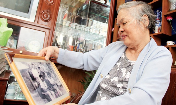 Bà Lịch xem lại những tấm ảnh kỷ niệm thời chiến.