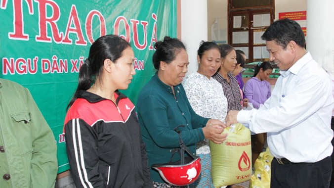 Bà con ngư dân xã Quảng Xuân, huyện Quảng Trạch (Quảng Bình) nhận quà của NHCSXH.