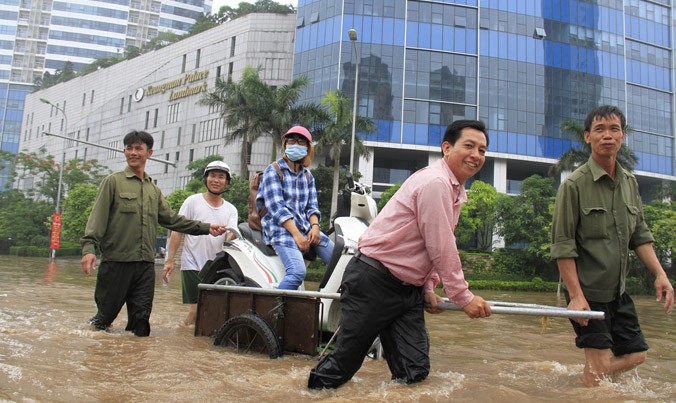 Hỗ trợ người và phương tiện bị chết máy trên đường Dương Đình Nghệ, đoạn trước tòa nhà Keangnam. Ảnh: Trường Phong.