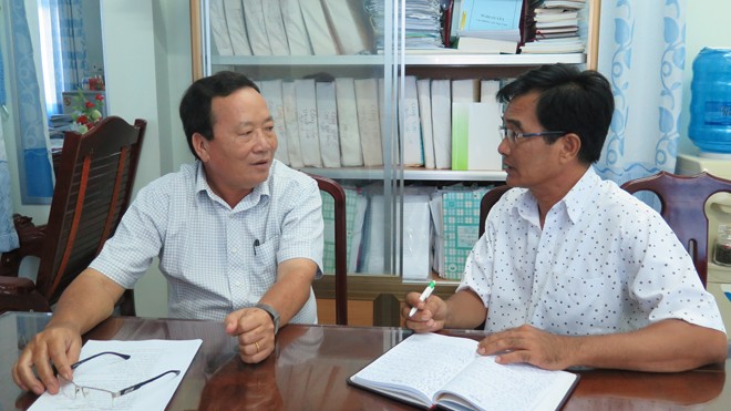Phóng viên báo Tiền Phong (phải) trao đổi với ông Phan Thành Đông, Chủ tịch UBND huyện Phước Long.
