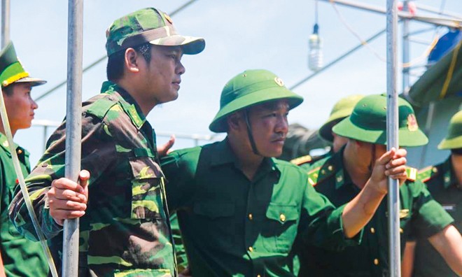 Thiếu tá Nguyễn Hữu Cường (đội mũ cối, giữa) không khỏi căng thẳng khi vừa trở về đất liền. Ảnh: V.H.