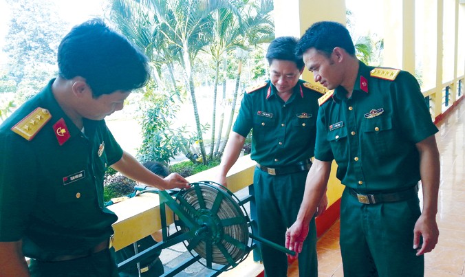 Thượng úy Nguyễn Văn Hoài (ngoài cùng bên phải) cùng đồng đội bên “Thiết bị bảo hiểm leo trèo nhà cao tầng”.
