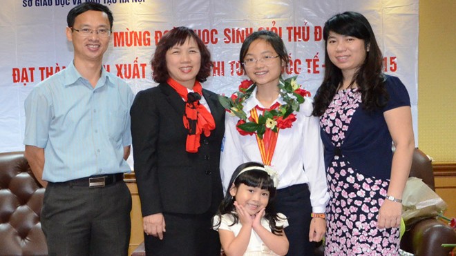 Nga Nhi cùng gia đình và cô giáo chủ nhiệm sau một lần nhận giải thưởng quốc tế.