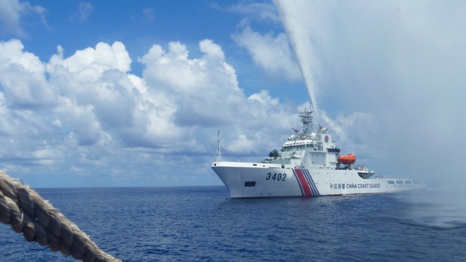 Tàu hải cảnh Trung Quốc xua đuổi ngư dân Philippines ở gần bãi cạn Scarborough trên biển Đông. Ngày 12/7, Tòa Trọng tài khẳng định, ngư dân Philippines có quyền đánh cá truyền thống ở Scarborough. Ảnh: AP.