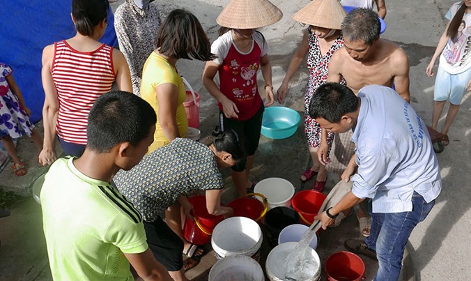 Người dân lấy nước từ xe téc tại ngõ 93 Hoàng Văn Thái.