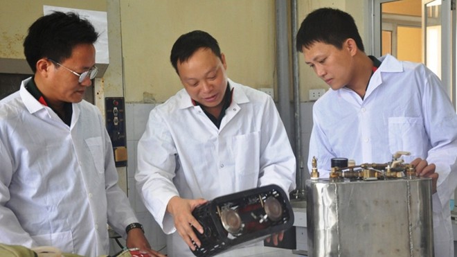 Đại úy Nguyễn Phi Hùng (ngoài cùng bên phải) trao đổi với lãnh đạo đơn vị về nguyên lý hoạt động của thiết bị chống khủng bố H-03.