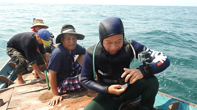 Phóng viên Tiền Phong (giữa) cùng các thợ lặn khảo sát môi trường đáy biển Quảng Bình. Ảnh: PV.