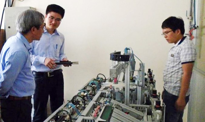 Nguyễn Văn Hùng (giữa) giới thiệu công nghệ chế tạo với các chuyên gia.