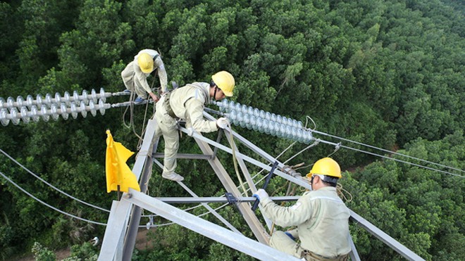 Ở độ cao khoảng 70m so với mặt đất, những người thợ truyền tải điện chỉ dùng chân và tay di chuyển dọc đường dây truyền tải điện để làm việc giữa trời nắng nóng.