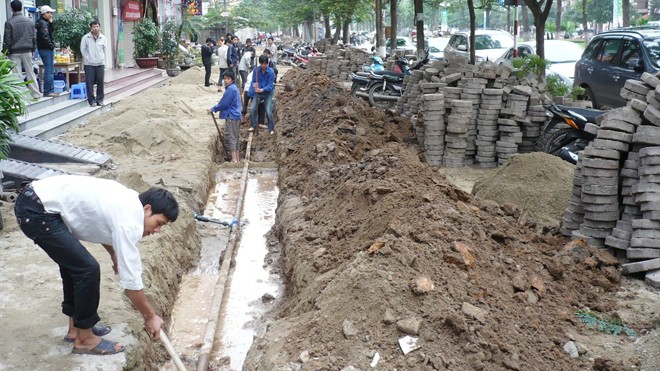 Vỉa hè đường Hoàng Quốc Việt từng được lát bằng gạch lục giác nhưng bị “mổ phanh” để sửa đường ống nước. Ảnh: Anh Trọng.