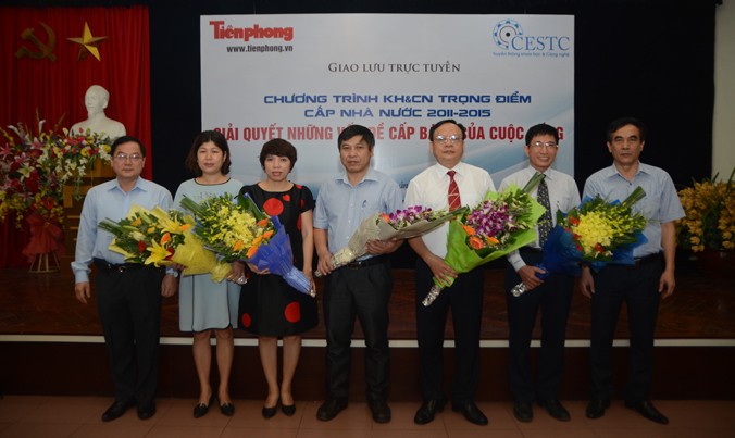 Tổng biên tập báo Tiền Phong Lê Xuân Sơn (ngoài cùng bên trái) và ông Nguyễn Xuân Toàn, Giám đốc Trung tâm Nghiên cứu và Phát triển truyền thông KH&CN (ngoài cùng bên phải) tặng hoa cho các khách mời giao lưu. Ảnh: Thanh Hà.