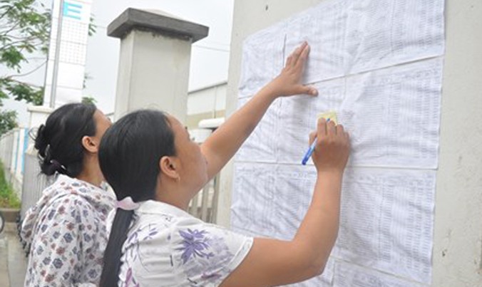 Công nhân ghi thông tin sổ BHXH trước cổng Cty TNHH Gmie (Bắc Ninh). Ảnh: T.T.
