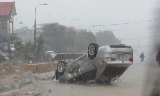 Một chiếc xế hộp bị lật trong mưa lớn ở TP Đồng Hới. Ảnh: H.N.